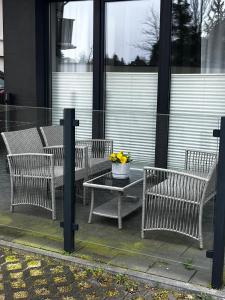 a group of benches and a table with flowers on it at Apartament Yellow Mielno in Mielno