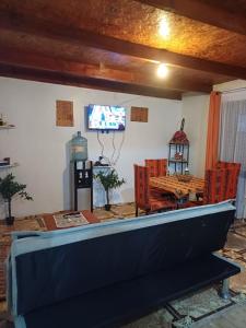 a living room with a tv and a table and chairs at Quyllur Ancestral in San Pedro de Atacama