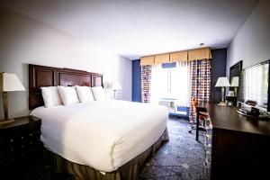 a hotel room with a large bed and a desk at Manistee Inn & Marina in Manistee