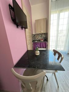 a dining room table with a tv on a pink wall at Borgo Levano in Licata