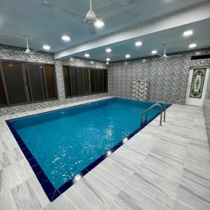 una grande piscina in una stanza con parete piastrellata di استراحة روضة الوادي a Nizwa