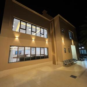 un bâtiment avec beaucoup de fenêtres la nuit dans l'établissement استراحة روضة الوادي, à Nizwa