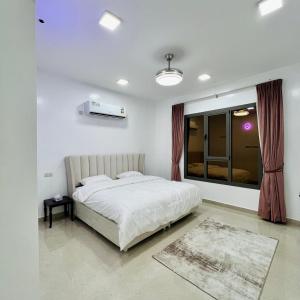 1 dormitorio con cama blanca y ventana en استراحة روضة الوادي en Nizwa