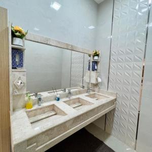 استراحة روضة الوادي في نزوى‎: حمام به مغسلتين ومرآة كبيرة