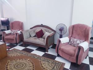 een woonkamer met 2 stoelen en een ventilator bij الياسمين تاور * Jasmin Tower in Caïro