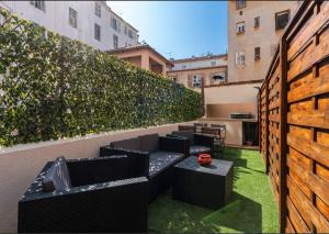 un patio en la azotea con muebles negros y césped verde en Loft place Masséna avec terrasse, en Niza