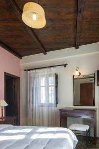 a bedroom with a bed and a dresser and a mirror at Porto Kale Guesthouse in Porto Kagio