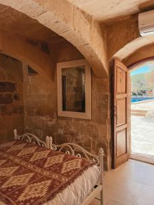 ein Schlafzimmer mit einem Bett und einer offenen Tür in der Unterkunft Soluna Boutique Guesthouse in Għasri