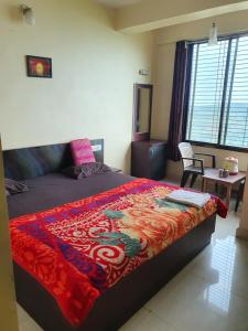 a bedroom with a bed with a colorful blanket on it at Hiral residency in Matheran