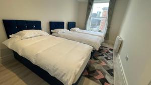 2 camas individuais num quarto com uma janela em Spire apartment no kitchen em Dublin