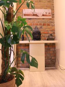 uma máscara preta sentada numa prateleira ao lado de uma parede de tijolos em Spire apartment no kitchen em Dublin