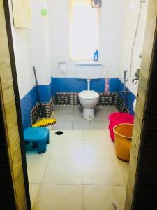 a bathroom with a white toilet and a window at Masum Villa in Nagaon
