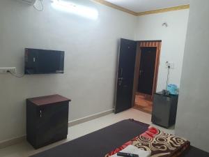 um quarto com uma televisão na parede e uma cama em Hiral residency em Matheran