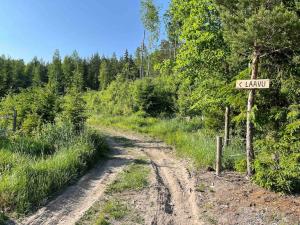 a dirt road with a sign that says k loader at Lammastilan laavu - Lean to Inarin tila in Salo