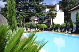 a swimming pool in front of a building at Hotel Jasmin in Merano