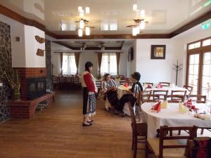 a group of people standing in a dining room at Pensiunea Casiana in Ciulpăz
