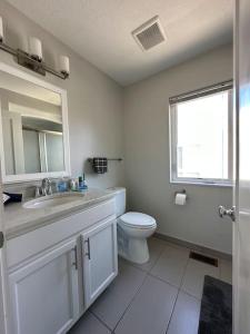 a white bathroom with a toilet and a sink at Luxury Downtown Townhome Unit 7 in Cleveland