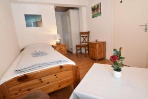 een slaapkamer met een bed en een tafel met een bloem erop bij fewo1846 - Monteurswohnung Fuchsbau - preiswerte Wohnung mit 3 Schlafzimmern in Flensburg