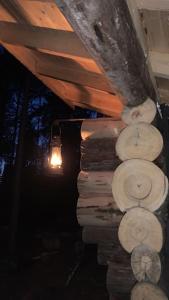 a stack of logs in a room with a light at Lammastilan laavu - Lean to Inarin tila in Salo