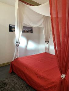 - une chambre avec un lit rouge à baldaquin dans l'établissement Comodo pied-à-terre ad Ascona, à Ascona