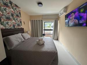 a bedroom with a bed with a teddy bear on it at Ondina Apart Hotel Residences in Salvador