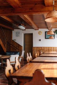 d'une salle de conférence avec des tables et des chaises et des plafonds en bois. dans l'établissement Turistická chata TJ TESLA BRNO, à Ostružná