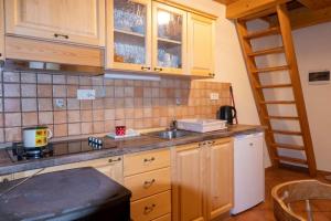 una cocina con armarios de madera, fregadero y escalera en Cottages Kravanja, en Trenta