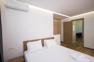 una camera con un letto bianco con due cuscini di Maistros Apartments Mykonos a Ftelia