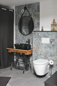 uma casa de banho com um lavatório, um WC e um espelho. em Loveroom la crèche romantique em Bogny Sur Meuse
