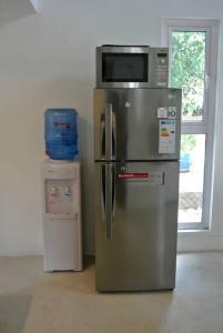 a microwave on top of a refrigerator in a room at Sanjana & Julien's in Tamarin