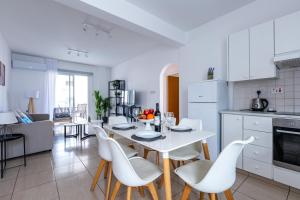 een keuken en een woonkamer met een witte tafel en stoelen bij Beautiful 2 bed apartment in Paphos Cyprus in Paphos City