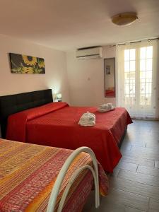 a bedroom with two beds with red sheets at Borgo Levano in Licata