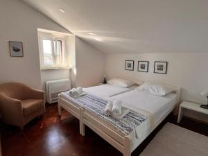 sypialnia z białym łóżkiem i krzesłem w obiekcie Apartman Oscar Mali Lošinj w miejscowości Mali Lošinj