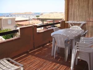 balcón con mesa, sillas y vistas al océano en Borgo Spiaggia Vista Mare, en Isola Rossa