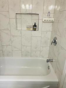 baño con bañera blanca y ventana en Sandy Hill Retreat - 3 Bedroom + Den, 2 Bath House with Fitness Equipment en Abbotsford