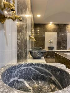 a bathroom with a large marble tub with a sink at SİVAS AZZE PALACE OTEL in Sivas