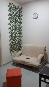 a couch in a room with a wall with a plant at AJ Hostel in Dubai