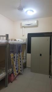 a room with two bunk beds and a door at AJ Hostel in Dubai