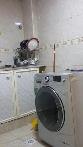 a kitchen with a washing machine in a room at AJ Hostel in Dubai