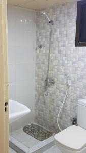 a bathroom with a shower with a toilet and a sink at AJ Hostel in Dubai