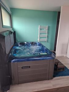 Habitación con baño con bañera azul. en Les Bulles du Guiers, en Saint-Genix-sur-Guiers