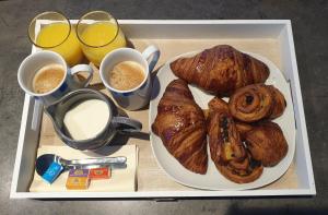 - un plateau avec une assiette de pain et deux tasses de café dans l'établissement Les Bulles du Guiers, à Saint-Genix-sur-Guiers