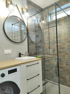 a bathroom with a sink and a glass shower at TOTU TODAY - POSNANIA - MALTA APARTAMENTY , Faktura VAT, self check-in, bezpłatny parking in Poznań