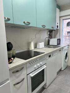 a kitchen with white appliances and blue cabinets at VuT El Refugio de Santiago in Ávila