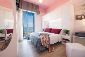 a bedroom with a bed and a view of the ocean at Hotel Eliseo in Bellaria-Igea Marina
