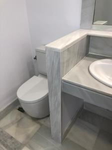 a bathroom with a white toilet and a sink at Juliana 3 home in Seville +19 photos