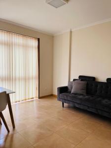 ein Wohnzimmer mit einem schwarzen Sofa und einem Tisch in der Unterkunft VIVE HOME Vilanova de Arousa in Vilanova de Arousa