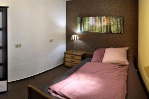 um pequeno quarto com uma cama e uma mesa de cabeceira em NiBo Hof - Ruhig und verkehrsgünstig em Goch