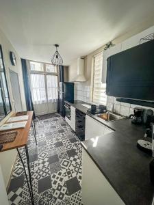 a kitchen with a black and white tile floor at La maison des Cordeliers in Loches