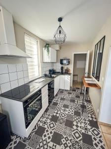 a kitchen with a black and white tile floor at La maison des Cordeliers in Loches